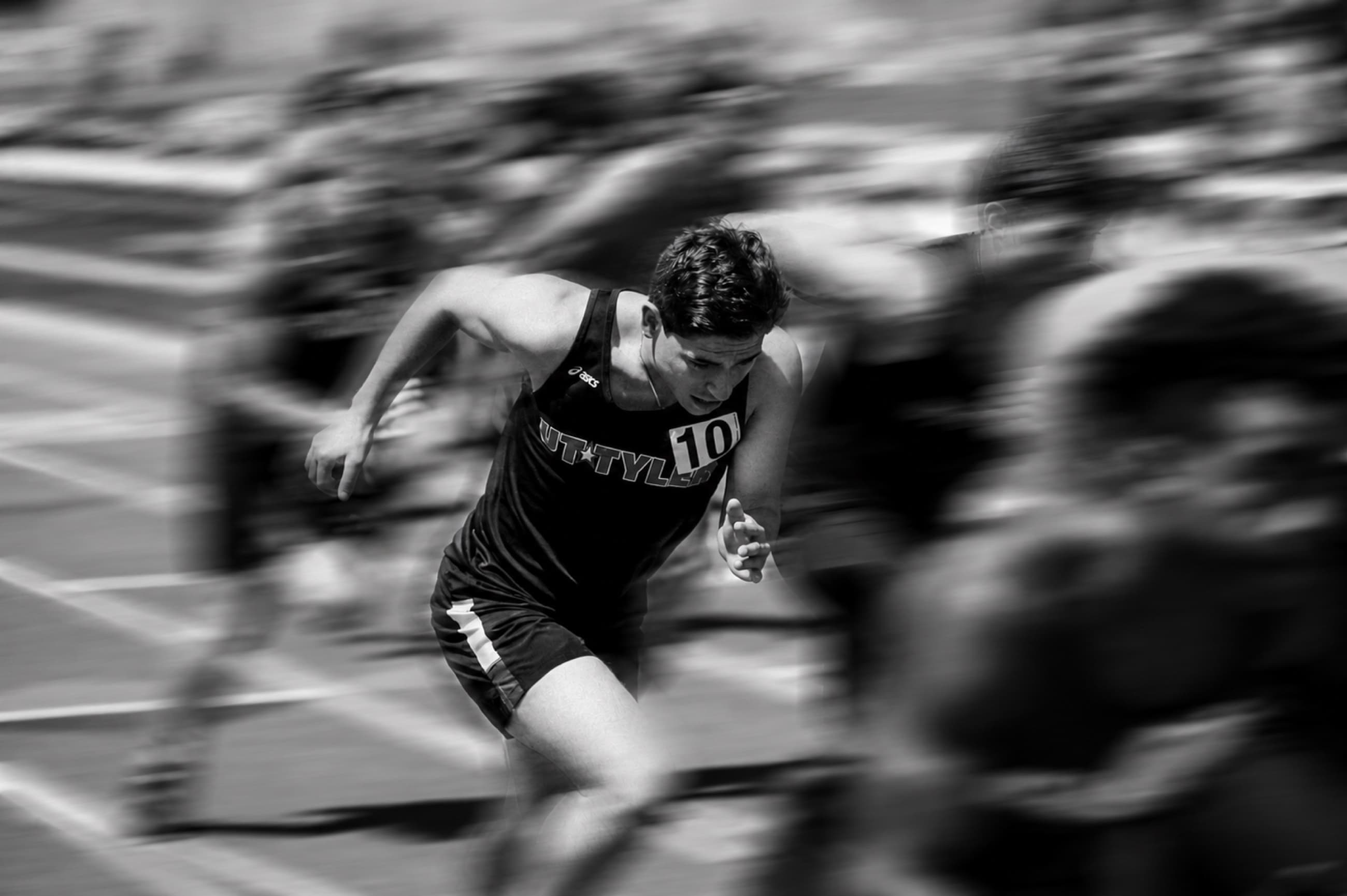 A runner sprinting through a blurred track scene.